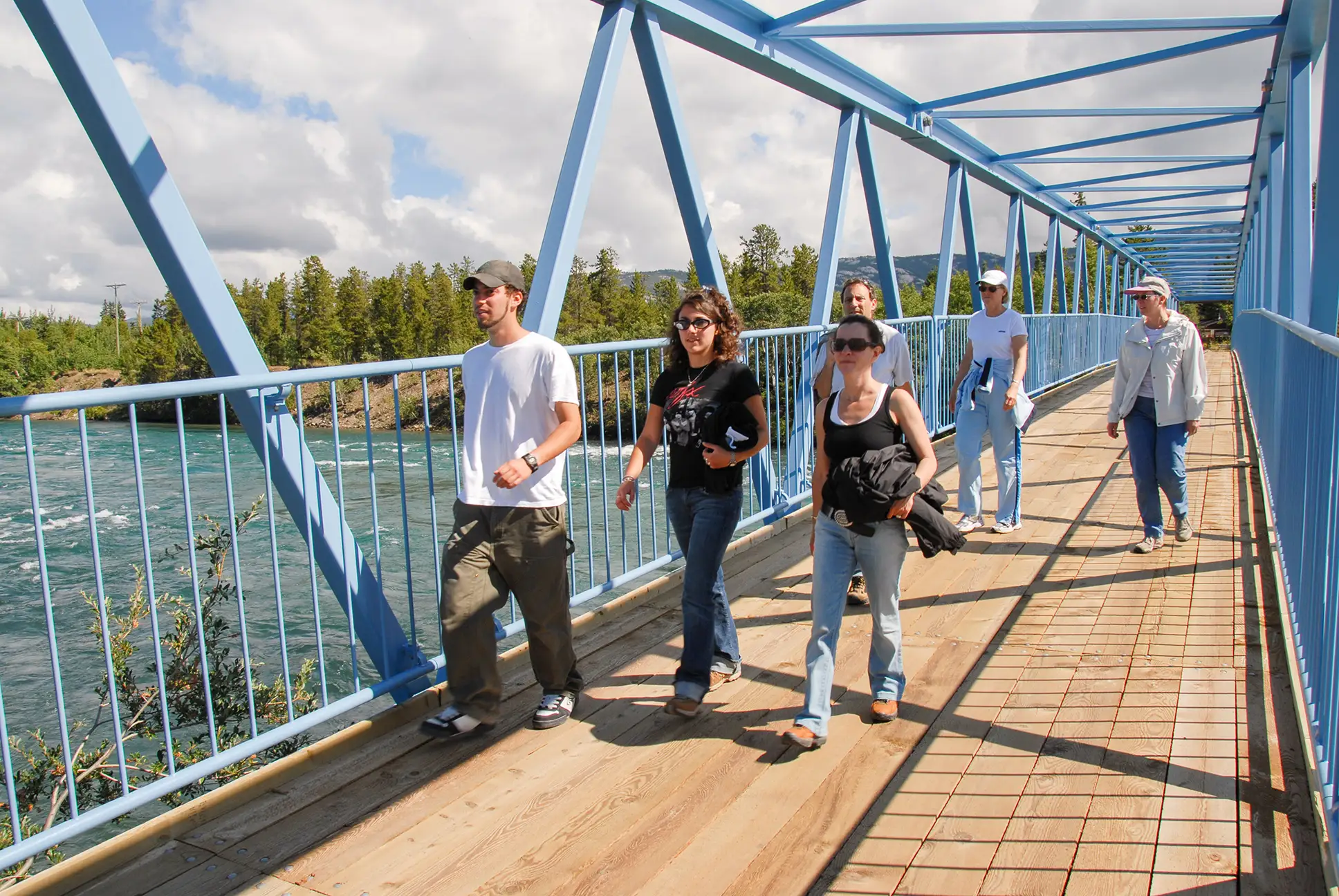 People walking on the millenium trail bridge crossing the Yukon River minutes from downtown Whitehorse, Yukon
